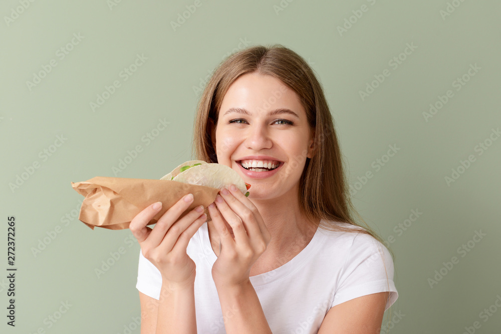 Woman eating tasty taco on color background Woman eating tasty taco on color background
