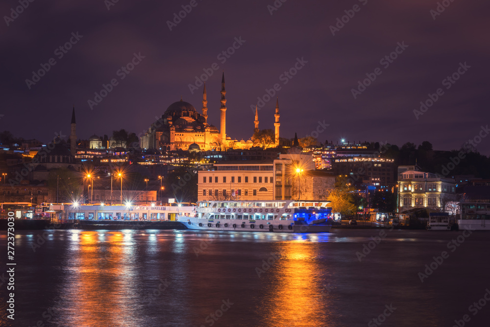 Istanbul cityscape at night, scenic view of city in lights with Eminonu station (Eminönü iskulesi), Blue Mosque and Golden Horn bay, Bosphorus, Turkey. Outdoor travel background