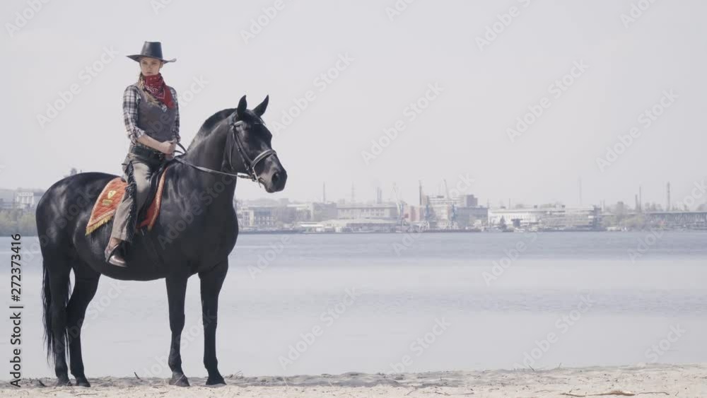 Sunny day on the shore of a river, a woman on the black horse, 4k Sunny day on the shore of a river, a woman on the black horse, 4k