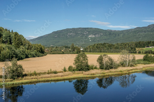 View over yellow fields by a river.