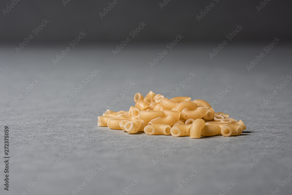 A pile of macaronis on grey background. A pile of macaronis on grey background.