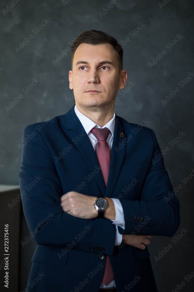 Portrait of young intelligent man lawyer standing with crossed arms in modern office building interior, successful male bank employee dressed in luxury suit posing with copy space area for your text Portrait of young intelligent man lawyer standing with crossed arms in modern office building interior, successful male bank employee dressed in luxury suit posing with copy space area for your text