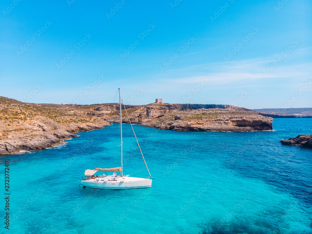 White yacht stands in azure transparent water sea, beach Blue Lagoon Comino Malta. Aerial view - obrazy, fototapety, plakaty 