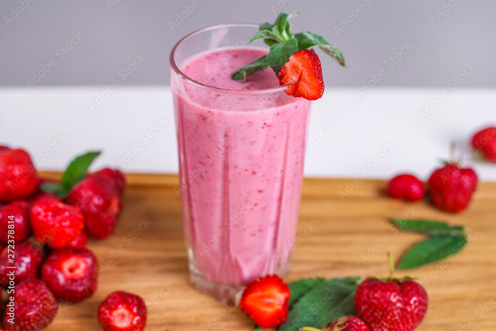 Glass with tasty strawberry smoothie on wooden table Glass with tasty strawberry smoothie on wooden table