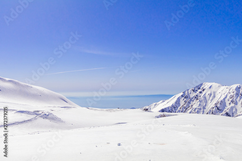 The japan alps  or the snow mountains wall  of Tateyama Kurobe alpine  in sunshine day with  blue sky background is one of the most important and popular natural place in Toyama Prefecture, Japan. © Umarin