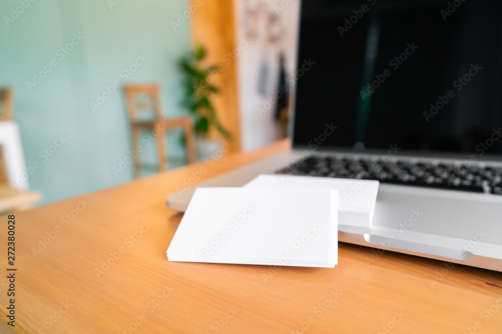 Blank business cards and laptop on wooden surface Blank business cards and laptop on wooden surface