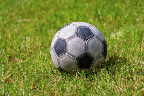 Close-up of an old leather soccer ball on green grass  football sport concept