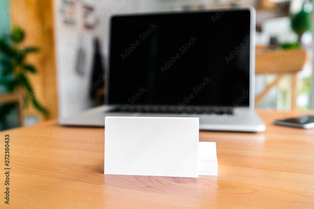Blank business cards and laptop on wooden surface Blank business cards and laptop on wooden surface