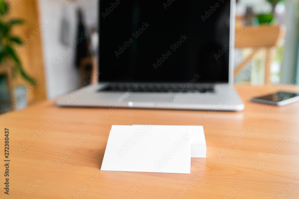 Blank business cards and laptop on wooden surface Blank business cards and laptop on wooden surface