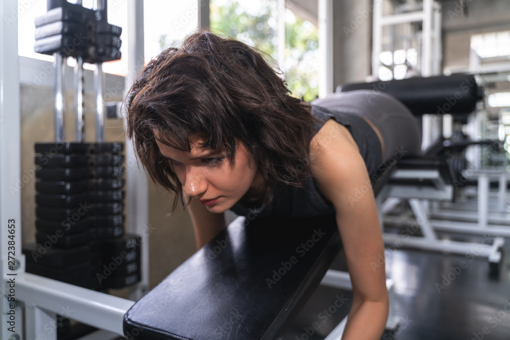 young fitness woman execute exercise with exercise-machine in gym. young fitness woman execute exercise with exercise-machine in gym.