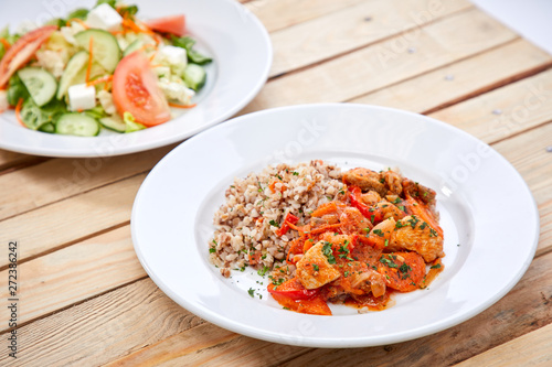 meat with buckwheat and salad on the wooden background