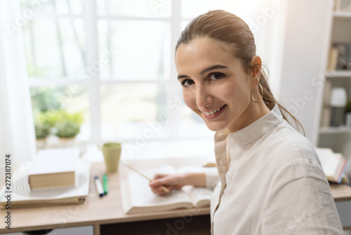 Woman studying at home and smiling