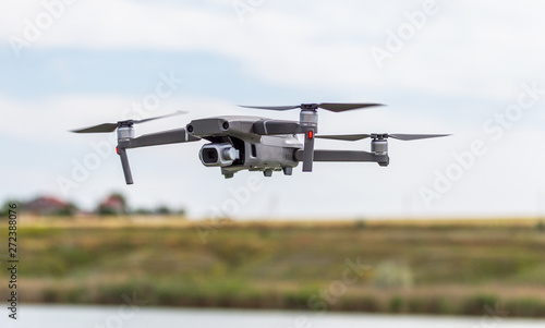 Professional filming drone flies in the air at a low altitude against a blue sky. Drone makes photos. Modern new technology. Ready background with place for your text