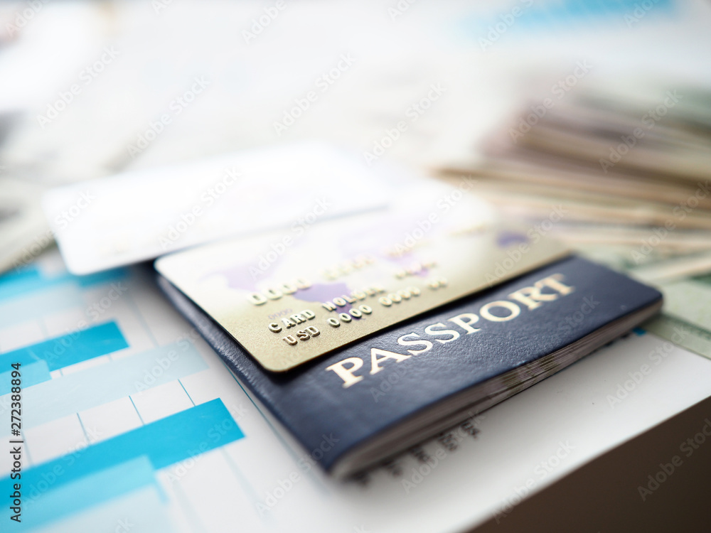Passport and plastic cards in USD lying on financial report document Passport and plastic cards in USD lying on financial report document