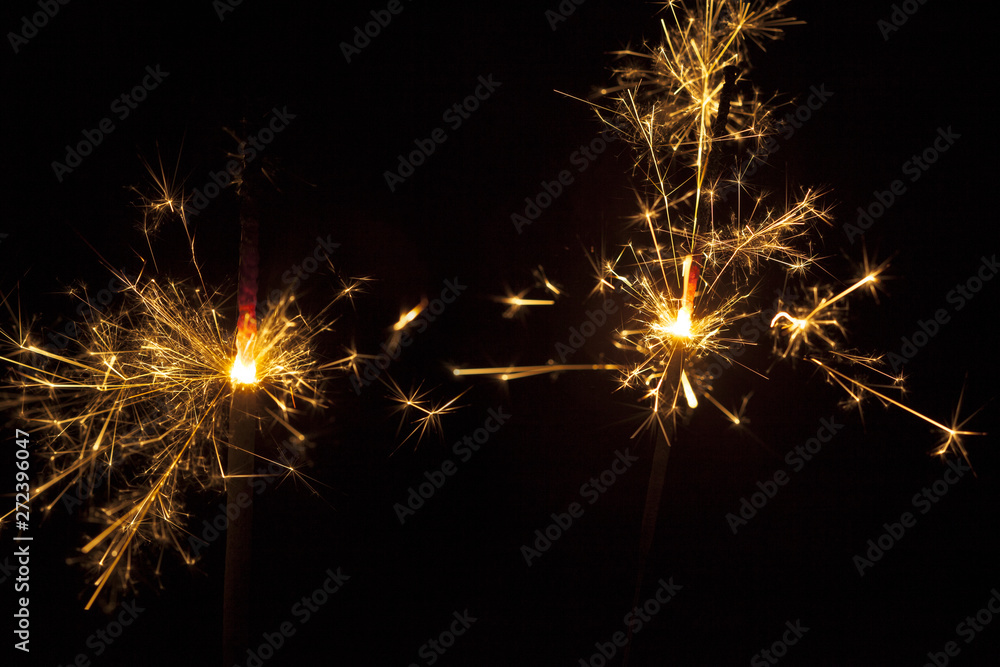 Dark background with two lit sparklers