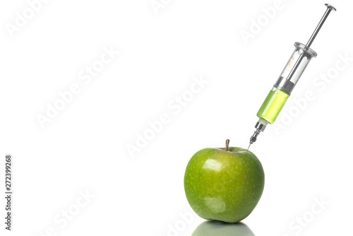 Injection into an apple, GMO concept, pesticides, poisons. White background.