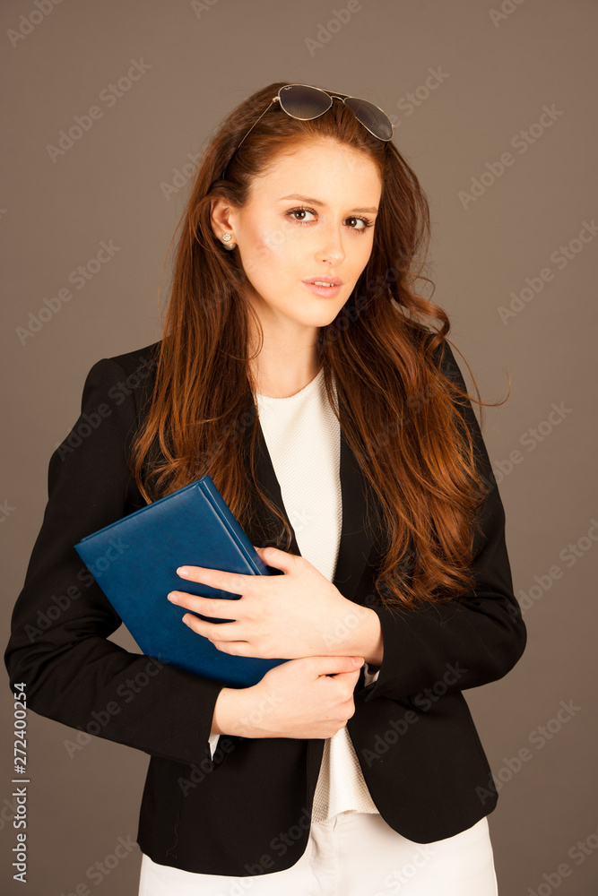attractive business woman with notebook over gray background attractive business woman with notebook over gray background
