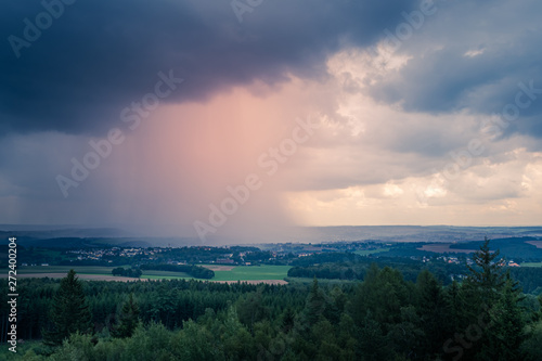 Stormy evening weather over rolling hills