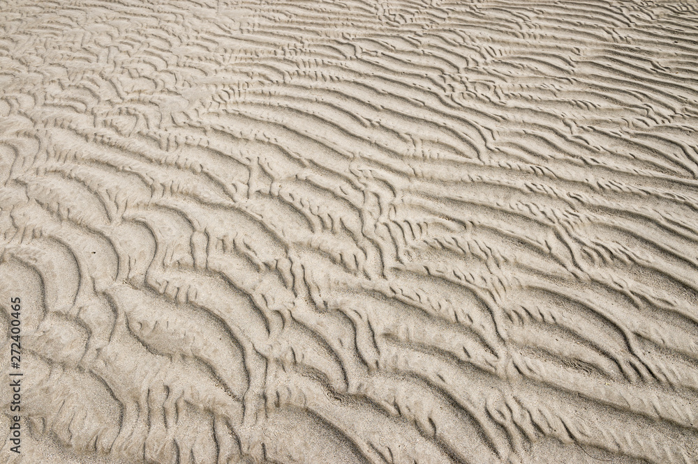Full frame abstract view of the natural graphic ripple pattern left in textured sand on a beach at low tide Full frame abstract view of the natural graphic ripple pattern left in textured sand on a beach at low tide