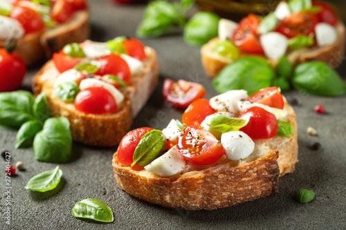 Bruschetta with tomatoes, mozzarella cheese and basil on a old rustic table Fototapeta