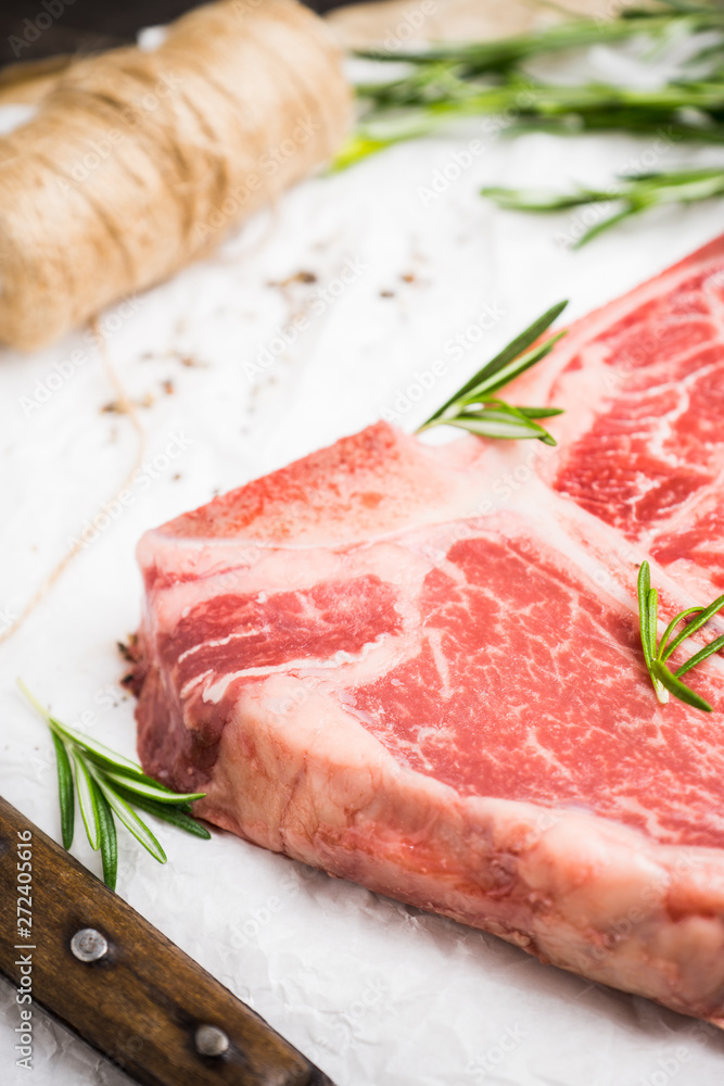 Raw fresh marble T-bone meat on the rustic background. Selective focus. Shallow depth of field.