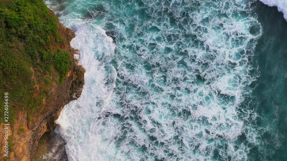 Drone, aerial or top view moving up away ocean blue waves crash coastline cliff drone footage. Rocky coast and crystal clear water. The water is like marble and crystal clear salt water. Waves break Drone, aerial or top view moving up away ocean blue waves crash coastline cliff drone footage. Rocky coast and crystal clear water. The water is like marble and crystal clear salt water. Waves break