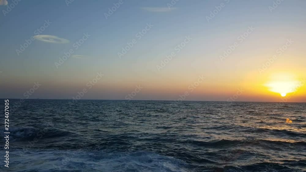View of the ocean and sunset. Sunset over blue ocean waves. Blue ocean and sunset on the horizon. View of the ocean and sunset. Sunset over blue ocean waves. Blue ocean and sunset on the horizon.
