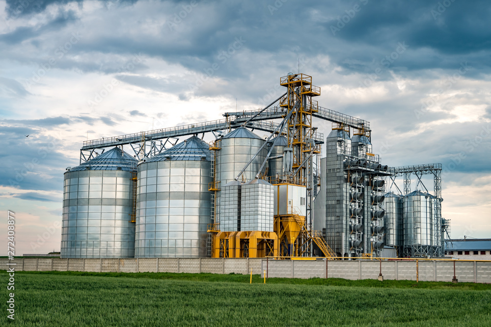 agro-processing plant for processing and silos for drying cleaning and storage of agricultural products, flour, cereals and grain with beautiful clouds agro-processing plant for processing and silos for drying cleaning and storage of agricultural products, flour, cereals and grain with beautiful clouds