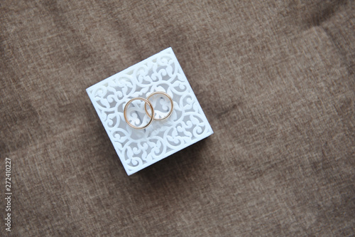 Beautiful wedding gold rings lie on a white box. Close-up, macro photography