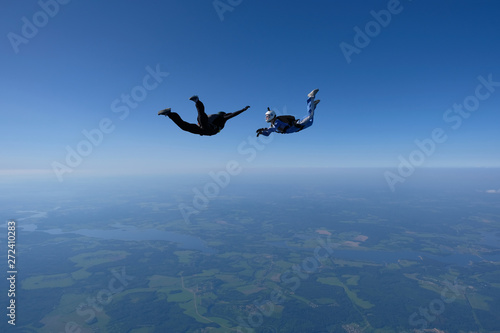Skydiving. An instructor trains a student to fly.