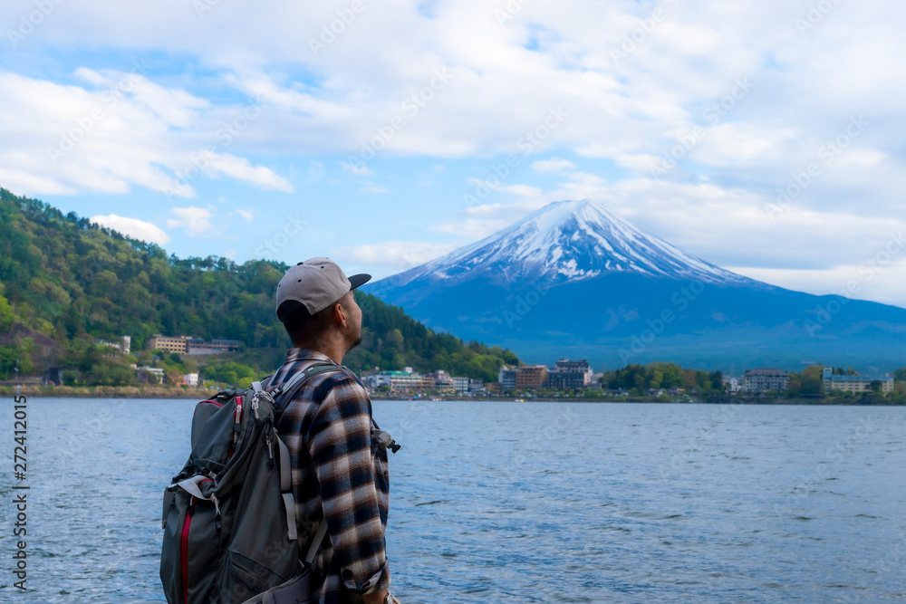 Young Boy Backpackers traveling Beautiful Fuji Mountain,  Men Backpacking Fujisan volcano at Kawaguchiko lake, Japan.