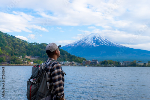 Young Boy Backpackers traveling Beautiful Fuji Mountain, Men Backpacking Fujisan volcano at Kawaguchiko lake, Japan.