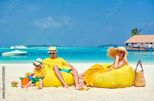 Fototapeta Naklejka Na Ścianę i Meble -  Family on beach, young couple in yellow with three year old boy. Summer vacation at Maldives.