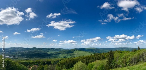 Scenic summer hike to the Wasserkuppe  the highest mountain of the Rhoen  Germany    its Radom  radar station during cold War  through lush green nature landscape with a bright blue sky   white clouds