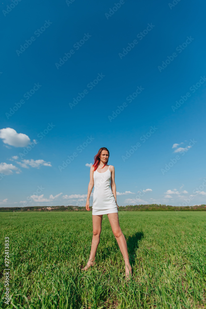 Girl in white short dress standing in the field Girl in white short dress standing in the field