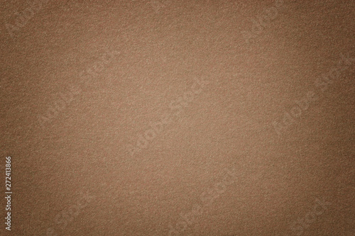 Light brown matt suede fabric closeup. Velvet texture of felt.