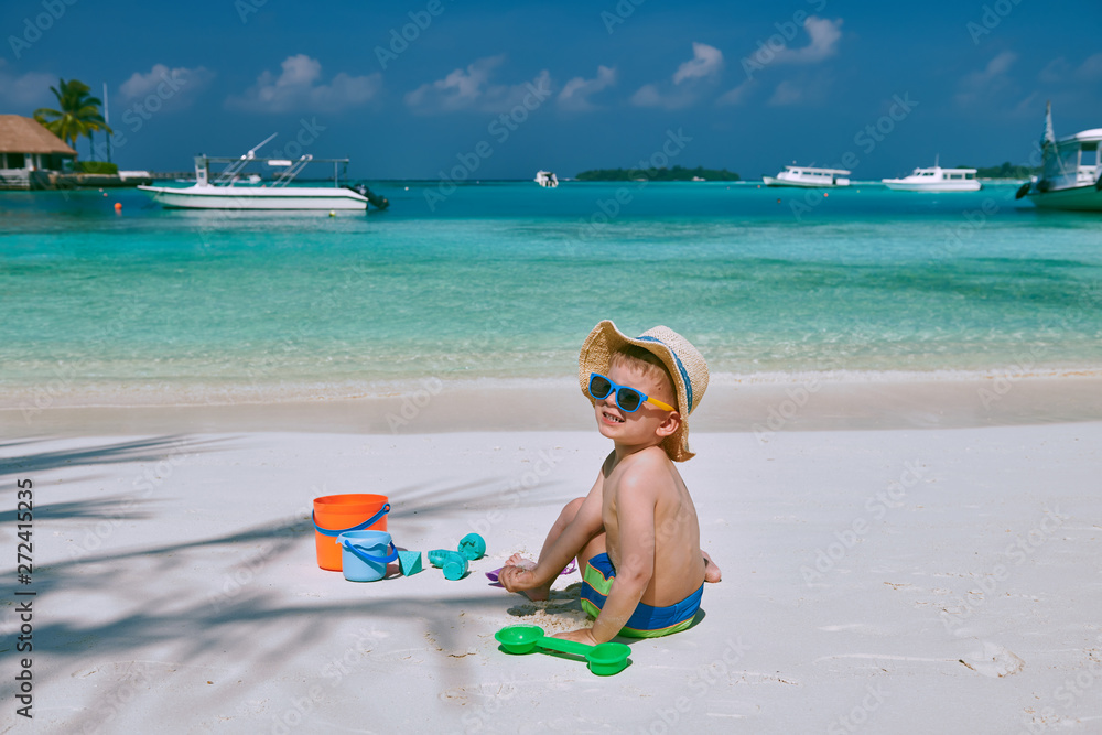 Three year old toddler boy playing with beach toys on beach. Summer family vacation at Maldives. Three year old toddler boy playing with beach toys on beach. Summer family vacation at Maldives.