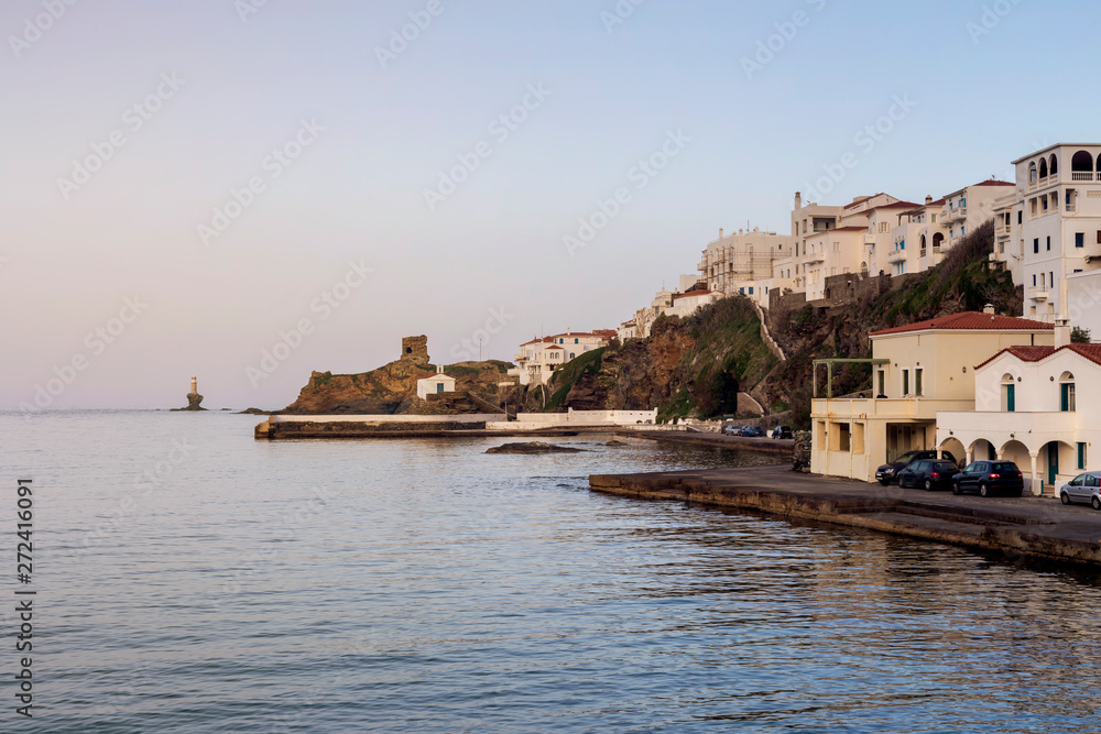 View of the town lighthouse, fortress, church and the sea (Greece, island Andros, Cyclades)