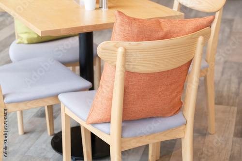 Modern orange fabric pillow on wooden chair decoration contemporary