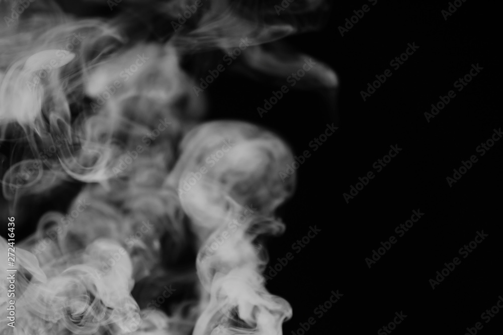 White smoke on a black background. Texture of smoke. Clubs of white smoke on a dark background for an overlay White smoke on a black background. Texture of smoke. Clubs of white smoke on a dark background for an overlay