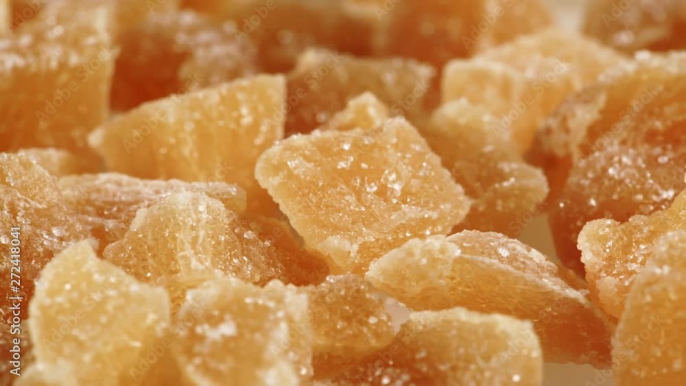 Close up heap of crystallized candied ginger pieces rotating.  Yummy snack, better alternative to candy