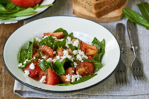 Tomato salad with sorrel and cottage cheese in a white bowl