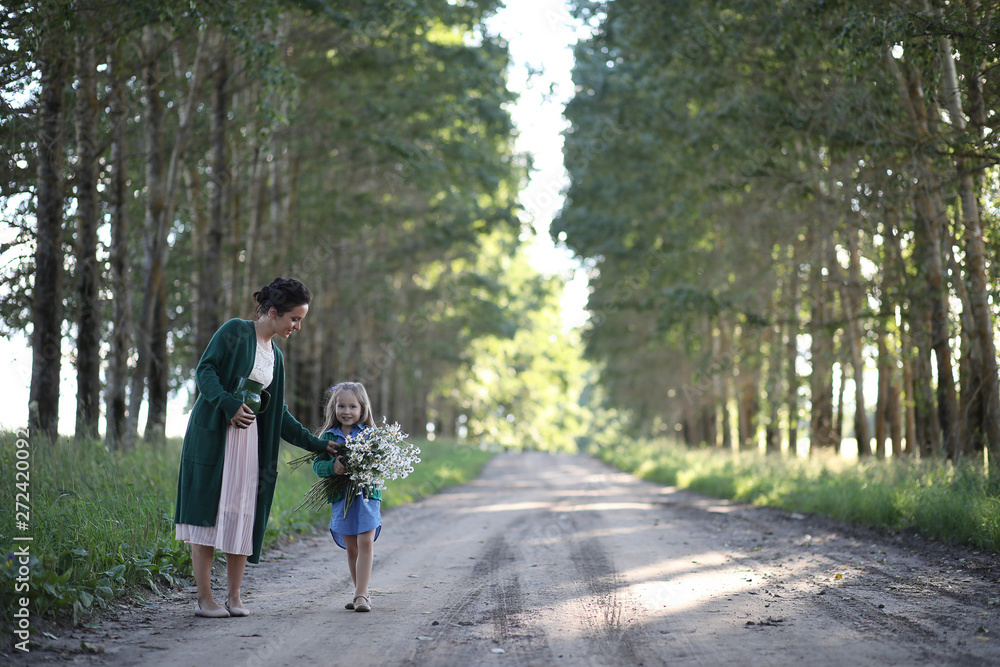 Mother with daughter walking on a road