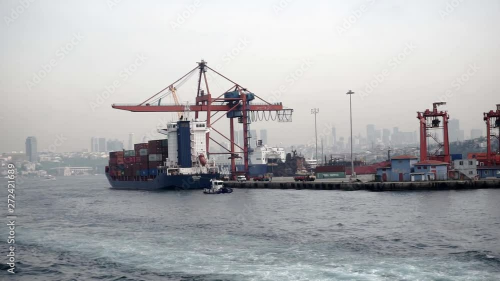 A large cargo ship stands in the port filled with iron containers with a crane A large cargo ship stands in the port filled with iron containers with a crane
