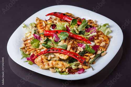 Mexican salad with hot pepper chiken fillet lettuce on plate
