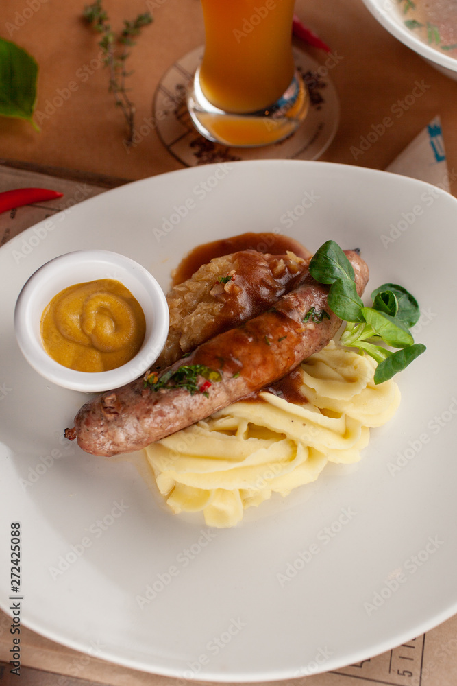 Traditional german sausage with mashed potato served with gravy and mustard