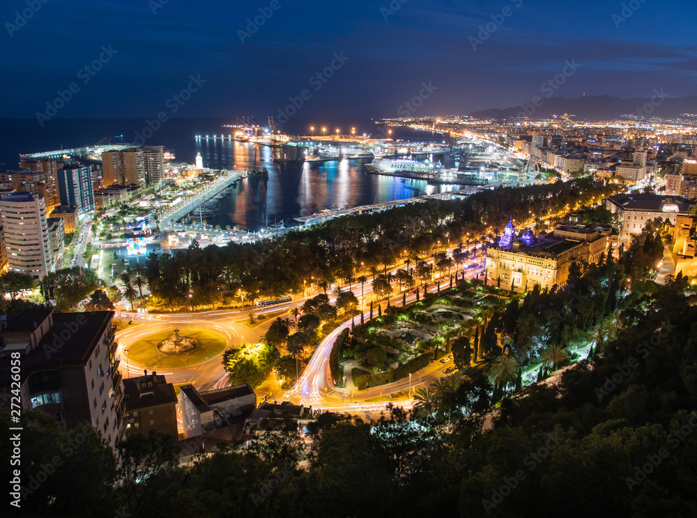 Fototapeta premium Cityscape and light trails of cars on highway, aerial view of Malaga, Spain