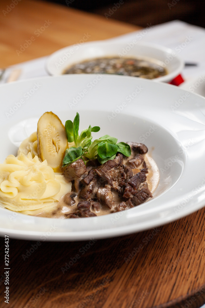 Classic russian beef stroganoff with white gravy and mashed potatoes served in a white plate Classic russian beef stroganoff with white gravy and mashed potatoes served in a white plate
