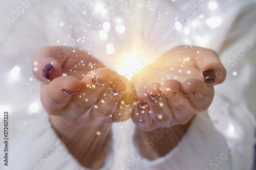 Fotografie magic particles on the palms of a woman, the flow of magical energy emanating from female hands