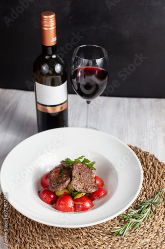 Mini bbq pork steaks with mashed potatoes and fragrant tomatoes, served with red wine